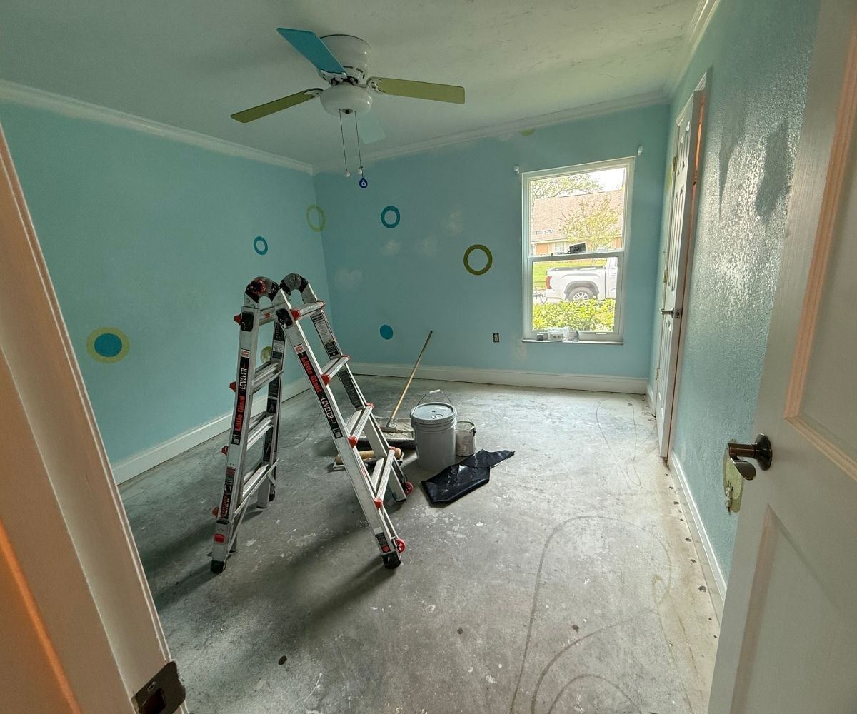 Bedroom before painting and flooring, teal walls and bare subfloor, in Saint Augustine, Florida