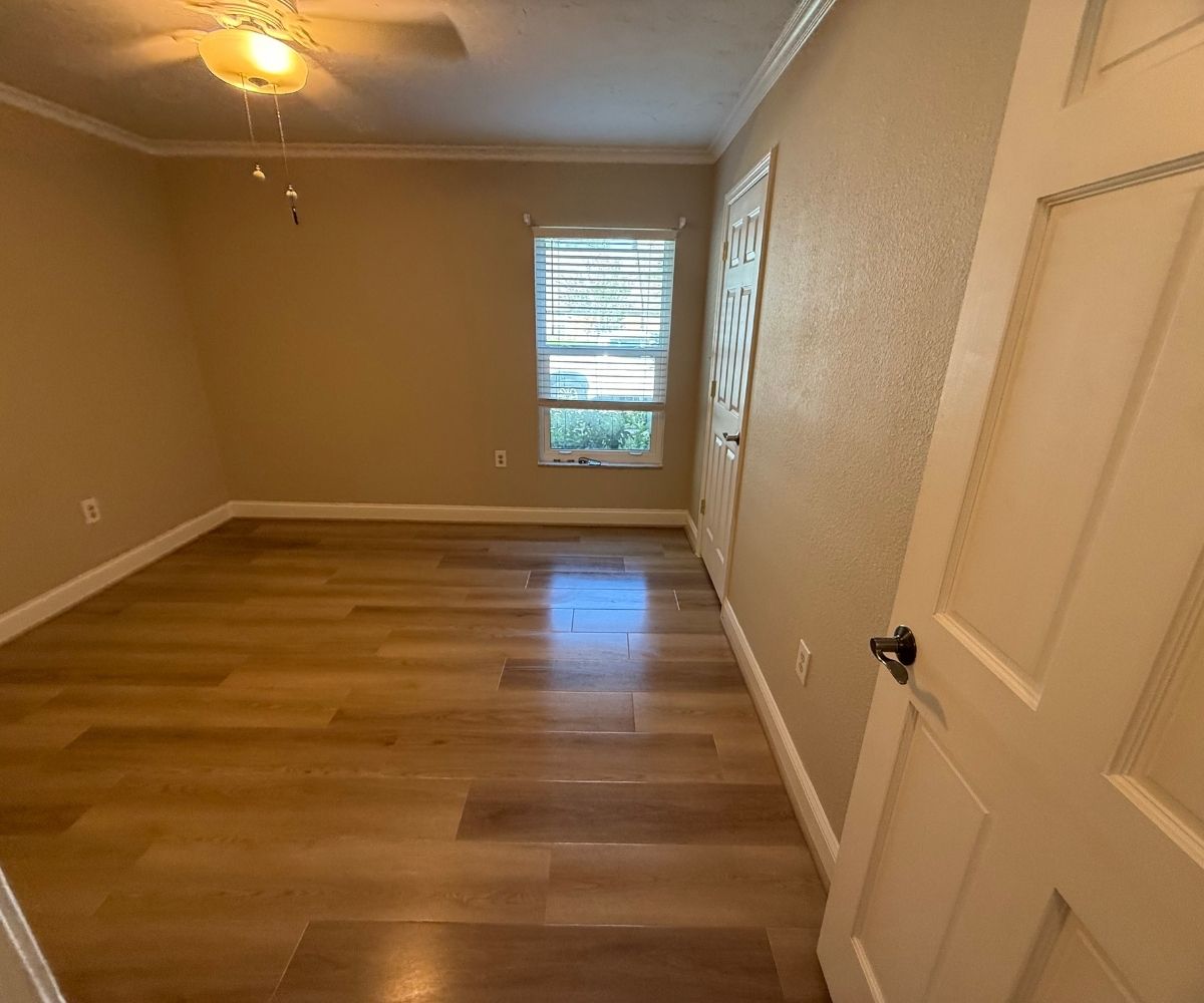 Same bedroom after repainting and luxury vinyl plank flooring installation in Saint Augustine, Florida