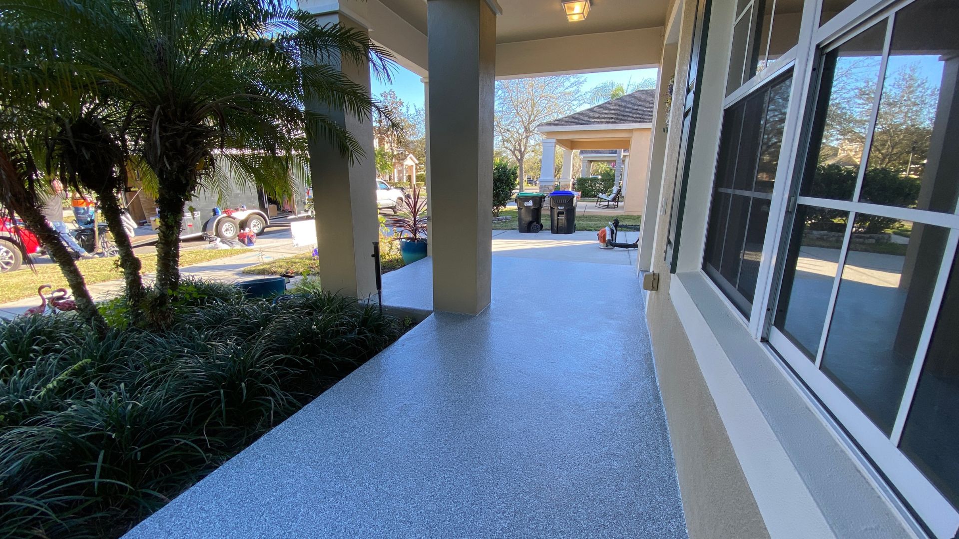 Finished gray flake concrete coating on a covered front porch and walkway in Saint Augustine, Florida