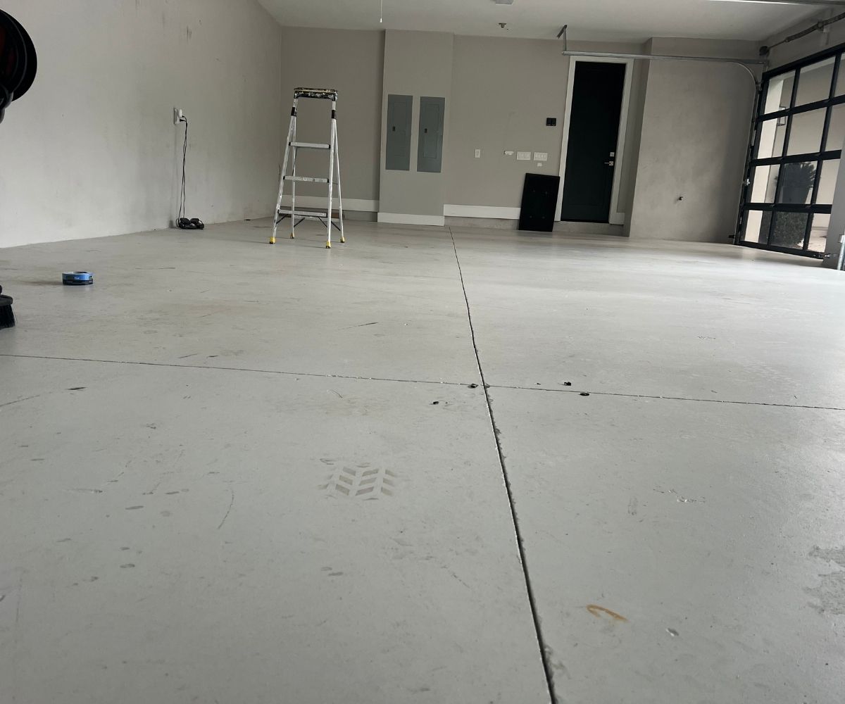 Bare, stained garage floor concrete before epoxy coating in Saint Augustine, Florida