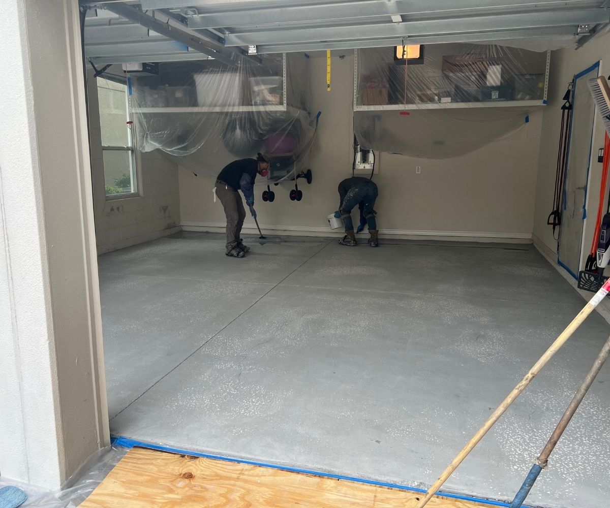 PD Home Pros crew applying the tinted epoxy base coat on a garage floor in Saint Augustine, Florida