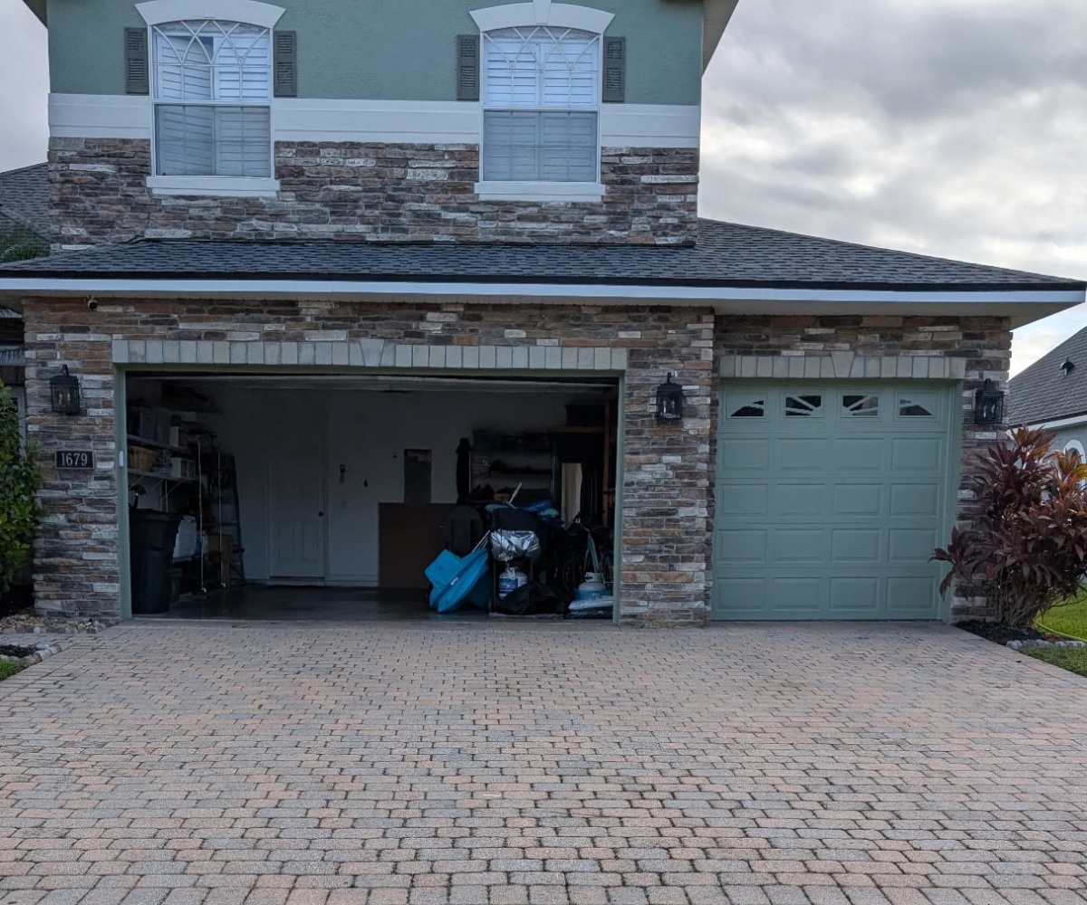 Faded paver driveway with arched garage before restoration in Saint Augustine, Florida
