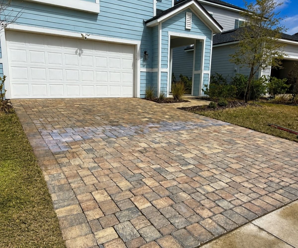 Half-sealed paver driveway showing before and after color in Saint Augustine, Florida