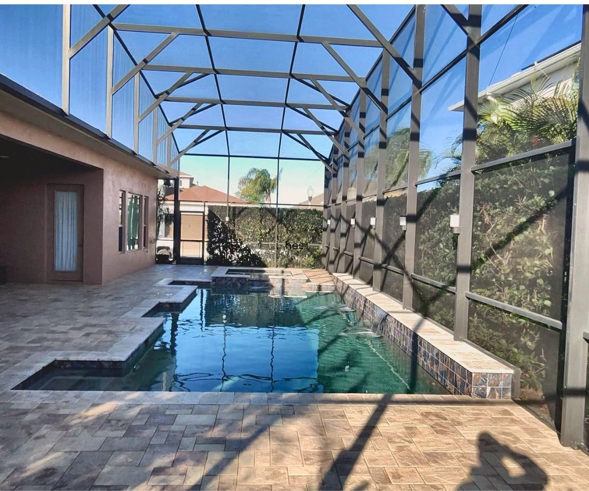 Sealed paver pool deck on a screened lanai with waterfall in Saint Augustine, Florida
