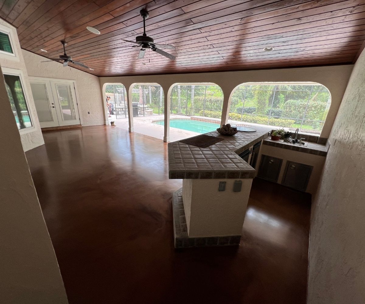 Finished stained concrete floor on a covered lanai with outdoor kitchen and pool view in Saint Augustine, Florida